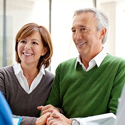 Smiling older couple at reception desk