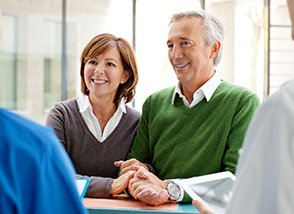 Older couple signing in at front desk