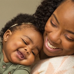 mother holding daughter smiling