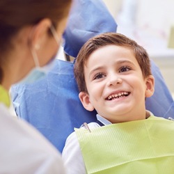 female dentist talking to little boy