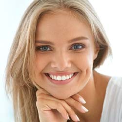 Woman smiling and resting her chin on her hand