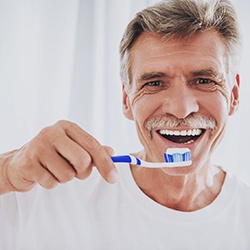 senior man brushing his teeth 