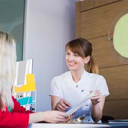 dental team member showing a patient a pamphlet