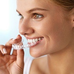 Woman placing Invisalign tray