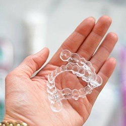Set of Invisalign trays in hand