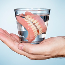 Full set of dentures in glass of water