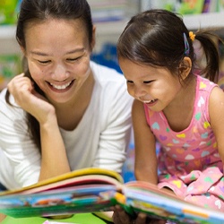 parent reading a book to their child in a library