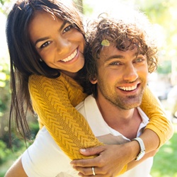 couple smiling hugging outside