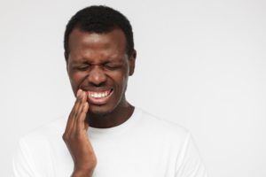 person with a toothache holding their mouth
