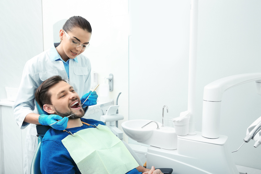 woman dentist working on male patient in office