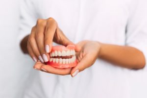 Hand holding upper denture